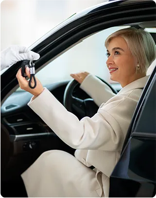 Marcus Müller UG – Fahrschule – eine Frau erhält Autoschlüssel von einem Parkservice-Mitarbeiter oder Chauffeur.